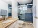 Renovated bathroom with blue tiled shower and granite vanity at 157 Golf Aire Blvd, Haines City, FL 33844