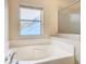 Bright bathroom featuring a large soaking tub and a window at 157 Golf Aire Blvd, Haines City, FL 33844