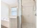 Bathroom featuring a glass shower enclosure and tiled tub at 157 Golf Aire Blvd, Haines City, FL 33844