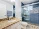 Renovated bathroom with blue tiled shower and granite vanity at 157 Golf Aire Blvd, Haines City, FL 33844