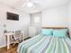 Bright bedroom featuring a window, desk, TV, wood floors, and a full bed with striped bedding at 157 Golf Aire Blvd, Haines City, FL 33844