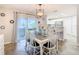 Bright dining room with sliding glass doors, rustic wood table, and white chairs at 157 Golf Aire Blvd, Haines City, FL 33844