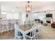 Open-concept dining area with modern lighting, a rustic table, and white chairs at 157 Golf Aire Blvd, Haines City, FL 33844