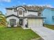 Charming two-story home featuring a two-car garage, manicured lawn, and beautiful dark and light exterior paint scheme at 157 Golf Aire Blvd, Haines City, FL 33844