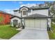 Charming two-story home featuring a two-car garage, manicured lawn, and beautiful dark and light exterior paint scheme at 157 Golf Aire Blvd, Haines City, FL 33844