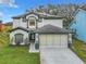 Charming two-story home featuring a two-car garage, manicured lawn, and beautiful dark and light exterior paint scheme at 157 Golf Aire Blvd, Haines City, FL 33844