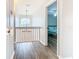 Bright upstairs hallway with wood floors, chandelier, window and an open bedroom doorway at 157 Golf Aire Blvd, Haines City, FL 33844