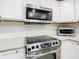 Gleaming stainless steel appliances stand out against the white cabinetry and granite countertops in the modern kitchen at 157 Golf Aire Blvd, Haines City, FL 33844
