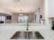 Modern kitchen sink with stainless steel fixtures, granite countertops, and an open view to the dining area at 157 Golf Aire Blvd, Haines City, FL 33844