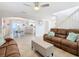 Bright open-concept living room featuring tile floors, ceiling fan, and views into the dining and kitchen areas at 157 Golf Aire Blvd, Haines City, FL 33844