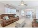 Open-concept living room with leather sofas and natural light, adjacent to the dining area at 157 Golf Aire Blvd, Haines City, FL 33844