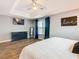 Main bedroom featuring tray ceiling, modern furnishings, and wood-look floors at 157 Golf Aire Blvd, Haines City, FL 33844