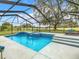 Stunning screened pool featuring an attached hot tub with a waterfall and a sprawling green yard at 157 Golf Aire Blvd, Haines City, FL 33844
