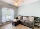 Comfortable sitting room with large window, tile floors, and sectional couch with throw pillows at 157 Golf Aire Blvd, Haines City, FL 33844