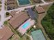 Aerial view of the community pool, clubhouse, and tennis courts, complete with lush landscaping and parking at 1573 Vienna Square Dr, Winter Haven, FL 33884
