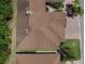 A high aerial view highlights brown rooftops interspersed among mature trees in a tranquil neighborhood at 1573 Vienna Square Dr, Winter Haven, FL 33884