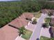 Aerial view of a home with a brown roof, surrounded by lush greenery and mature trees at 1573 Vienna Square Dr, Winter Haven, FL 33884