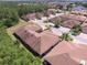 A birds-eye-view features well-maintained rooftops with a backdrop of green trees and lush landscape at 1573 Vienna Square Dr, Winter Haven, FL 33884