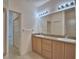Bright bathroom with double sinks, large mirror, and a walk-in shower at 1573 Vienna Square Dr, Winter Haven, FL 33884