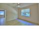 A bright empty bedroom with tile floors, ceiling fan, and a large window at 1573 Vienna Square Dr, Winter Haven, FL 33884
