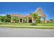Clubhouse exterior with well-manicured landscaping, elegant entrance, and ample parking at 1573 Vienna Square Dr, Winter Haven, FL 33884