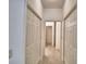 Hallway with multiple closet doors and tile flooring, providing ample storage space at 1573 Vienna Square Dr, Winter Haven, FL 33884