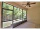 Enclosed lanai featuring an outdoor ceiling fan and views of the lush green backyard at 1573 Vienna Square Dr, Winter Haven, FL 33884