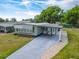 Charming home featuring a covered entryway, a long driveway, and a well-maintained lawn at 1610 Reynolds Rd # 242, Lakeland, FL 33801