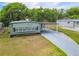 Exterior of home with a covered driveway and green siding at 1610 Reynolds Rd # 242, Lakeland, FL 33801