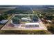 Wide aerial view of property with surrounding agriculture, a home and outbuildings, and boundary outlined in white at 1646 Tyner Rd, Haines City, FL 33844