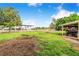 Backyard space with covered equipment storage next to a grassy area and wooded area at 1646 Tyner Rd, Haines City, FL 33844