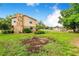Large backyard with a stone chimney and a storage area beyond the grass at 1646 Tyner Rd, Haines City, FL 33844