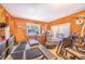 Wood paneled exercise room offering a treadmill and weight lifting station with natural light at 1646 Tyner Rd, Haines City, FL 33844