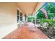 Covered front porch with mosaic tile, seating, and view of the lush yard and garden at 1646 Tyner Rd, Haines City, FL 33844