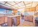 Spacious kitchen has natural wood cabinets, eat-in seating, an island, and stainless appliances at 1646 Tyner Rd, Haines City, FL 33844