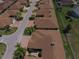 Aerial view of multiple brown roofed homes with red brick driveways, set amongst manicured lawns and streets at 1674 Linz Ct, Winter Haven, FL 33884