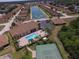 Aerial view of the community featuring a pool, tennis court, lake, and meticulously maintained grounds at 1674 Linz Ct, Winter Haven, FL 33884