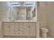 Bathroom featuring a double sink vanity, toilet, and large mirror at 1674 Linz Ct, Winter Haven, FL 33884