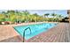 Community pool with lounge chairs and well-manicured landscaping offers a refreshing outdoor experience at 1674 Linz Ct, Winter Haven, FL 33884