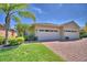 Charming home with a three-car garage, lush landscaping, and brick driveway at 1674 Linz Ct, Winter Haven, FL 33884