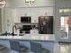 Modern kitchen with stainless steel appliances, a breakfast bar, and access to the outdoor patio at 1681 Waterview Loop, Haines City, FL 33844