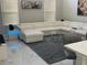 Cozy living room with a large white sectional sofa, a round glass table, and natural light at 1681 Waterview Loop, Haines City, FL 33844