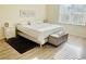 Sunlit bedroom with a comfortable bed, ottoman, and wood floors at 1760 Carnostie Rd, Winter Haven, FL 33884