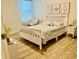 Cozy bedroom with a white bed frame, plush chair, and natural light at 1760 Carnostie Rd, Winter Haven, FL 33884