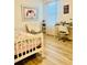 Comfortable bedroom featuring light wood floors, stylish decor, desk, and a large window for natural light at 1760 Carnostie Rd, Winter Haven, FL 33884