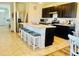 Kitchen island with bar stool seating, stainless appliances, and dark wood cabinets at 1760 Carnostie Rd, Winter Haven, FL 33884