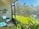 Charming screened patio with comfortable seating, decorative plants, and a view of the backyard pond at 1760 Carnostie Rd, Winter Haven, FL 33884