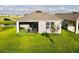 Back of house with a screened lanai, a view of a pond, and a well-maintained lawn at 1760 Carnostie Rd, Winter Haven, FL 33884