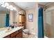 Bathroom with vanity, vessel sink, nautical decor, framed mirror, shower-tub combo with blue shower curtain at 177 Costa Loop, Auburndale, FL 33823
