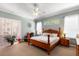 Cozy bedroom with a ceiling fan, plush carpet, and a large window with an outdoor view at 177 Costa Loop, Auburndale, FL 33823